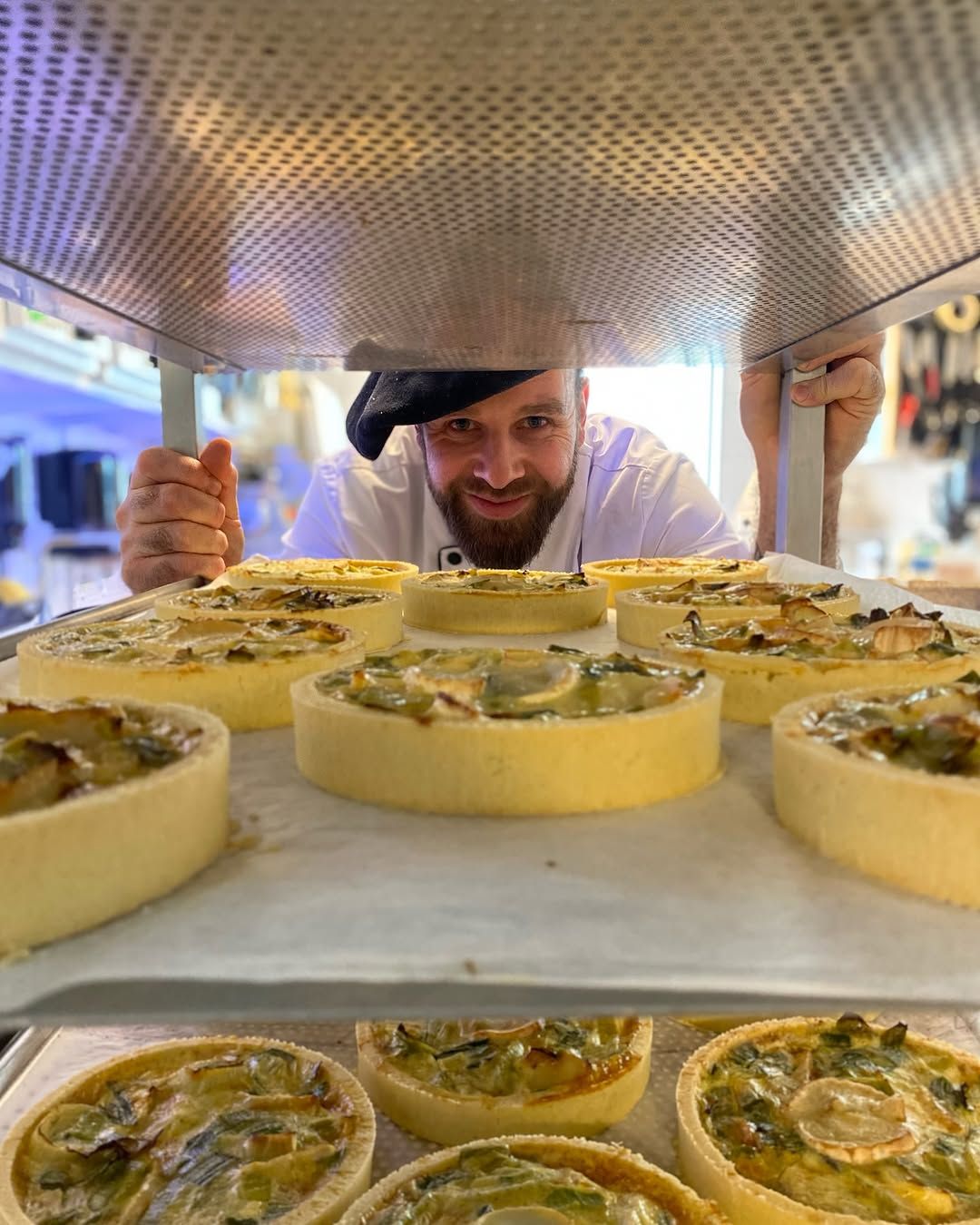 Baker with freshly baked quiches