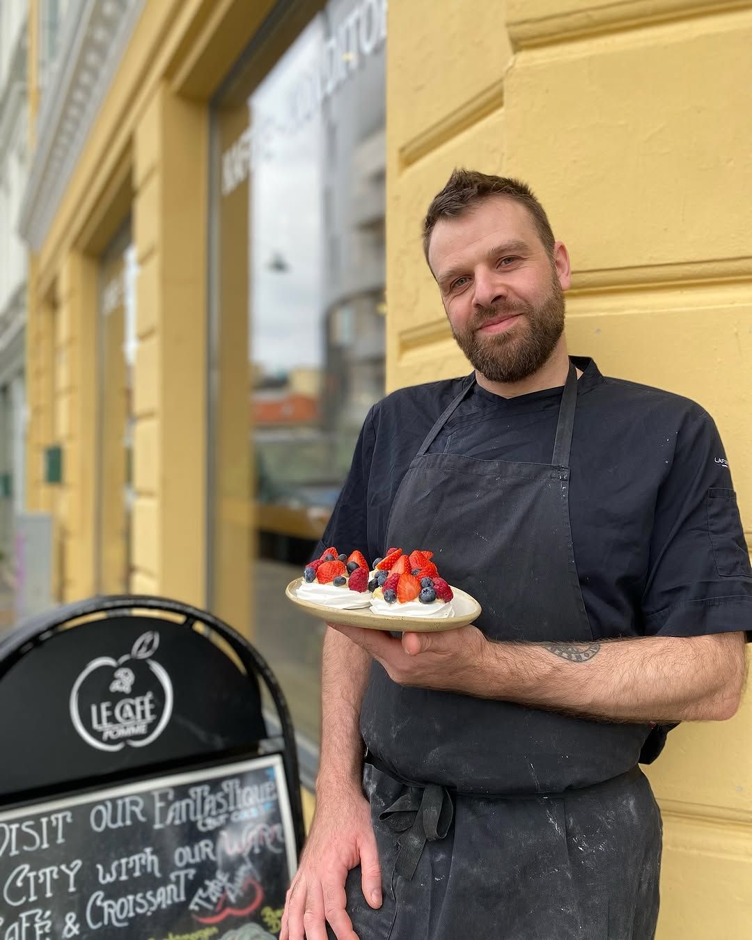 Chef outside Le Café Pomme with berry pavlova